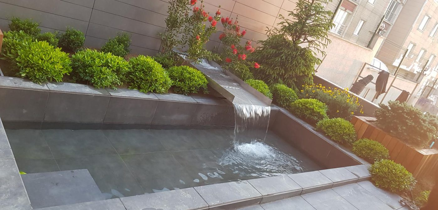 Moderne tuinwaterval in een stenen wand