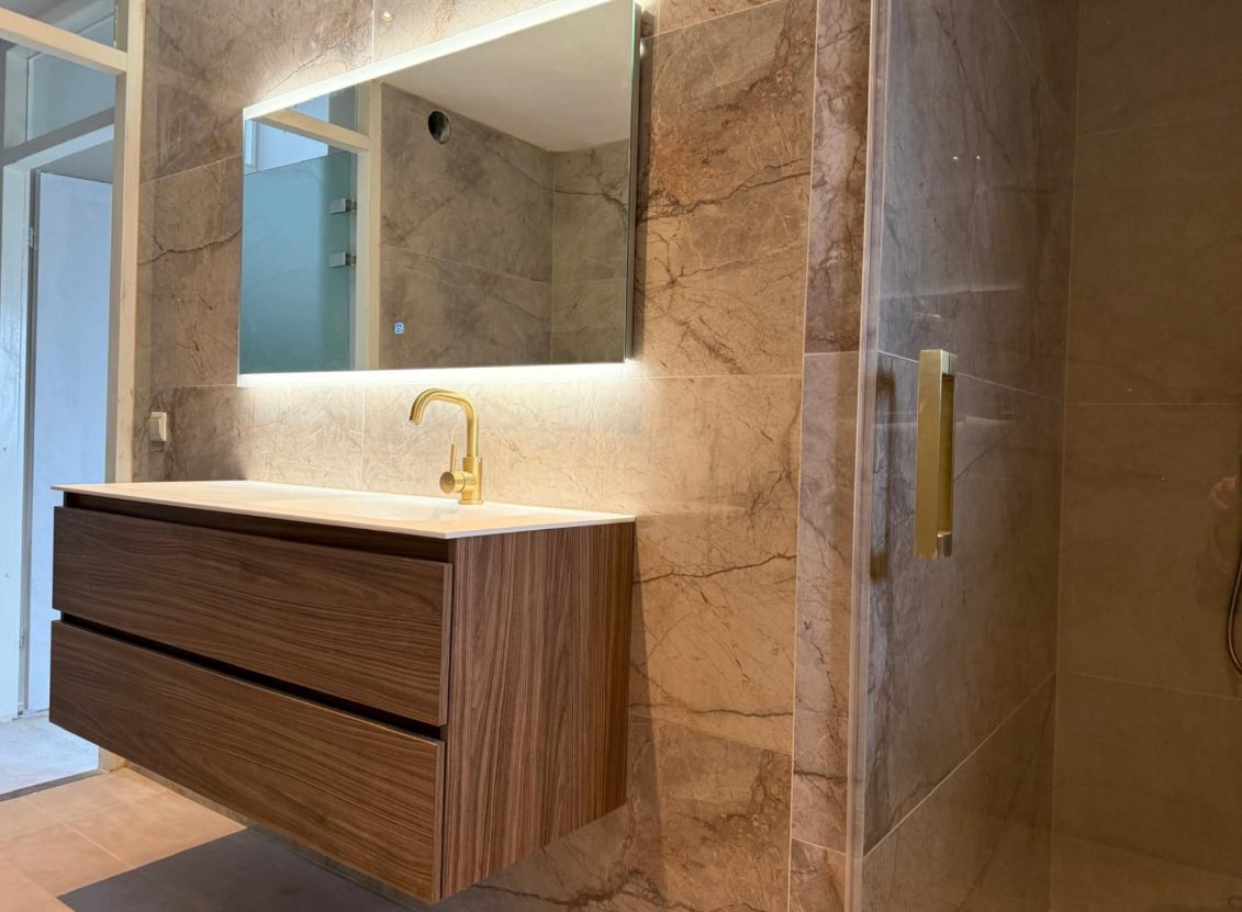 Moderne badkamer met houten wastafelmeubel en marmerlook tegels