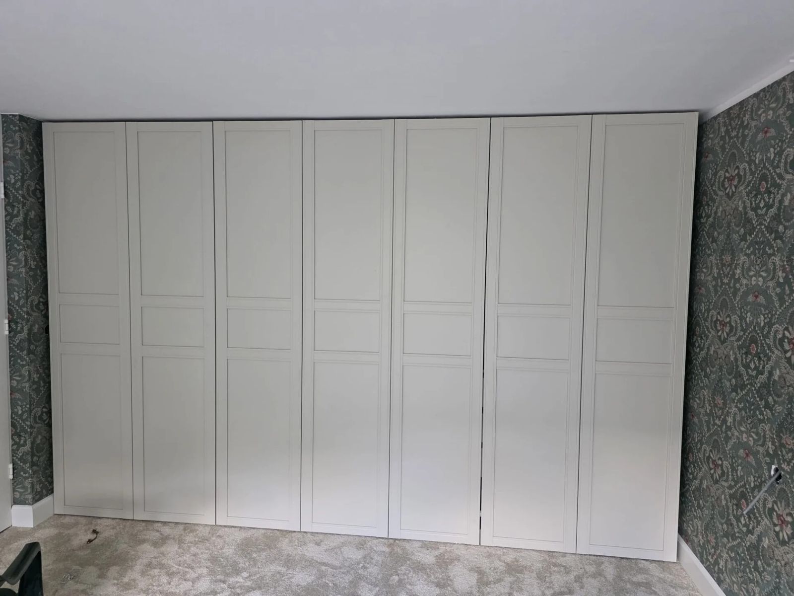 Maatwerk kastenwand in hout, strak ingebouwd van vloer tot plafond