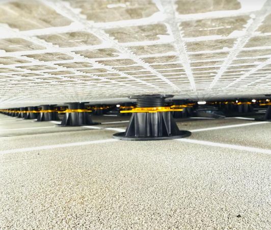 Verstelbare tegeldragers onder een terras voordat de tegels worden gelegd