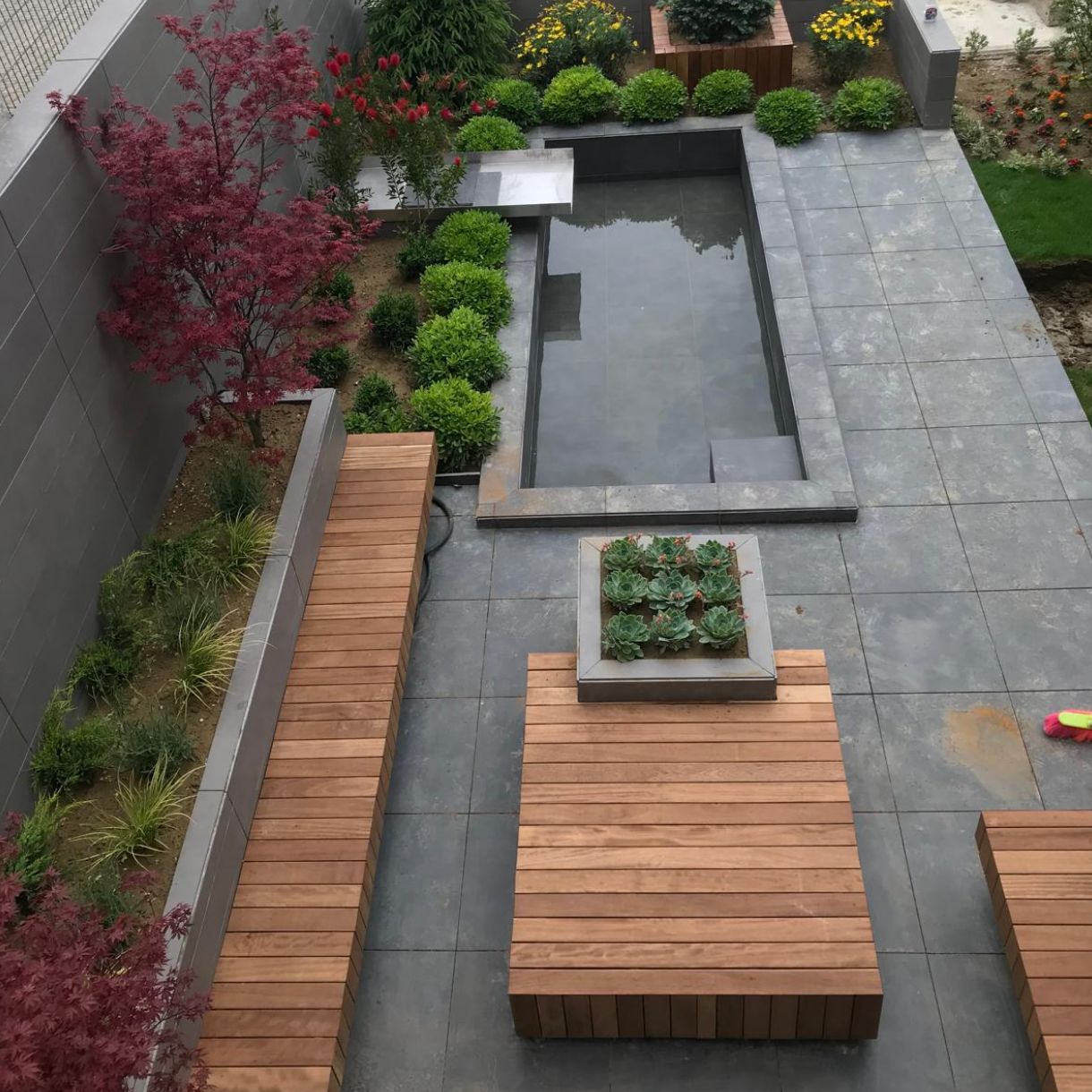 Aangelegde tuin met waterpartij, bestrating en beplanting